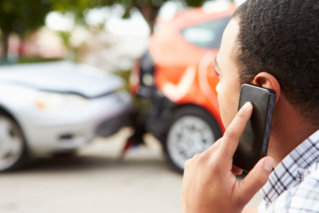 Man on phone making a call after fender bender car accident