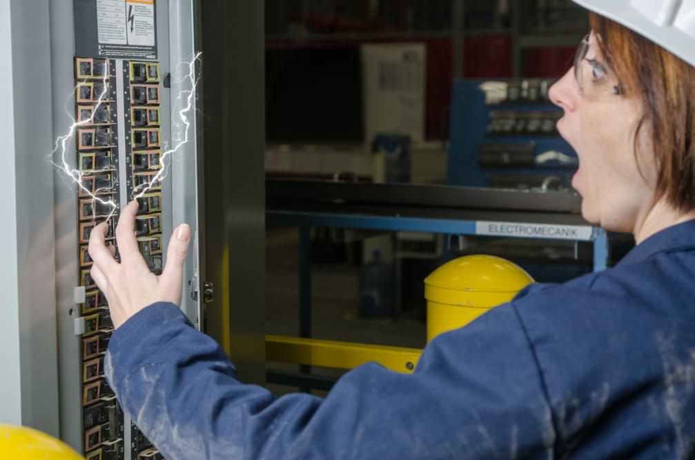 Woman working on fuse box being electrocuted by fuse box sparks