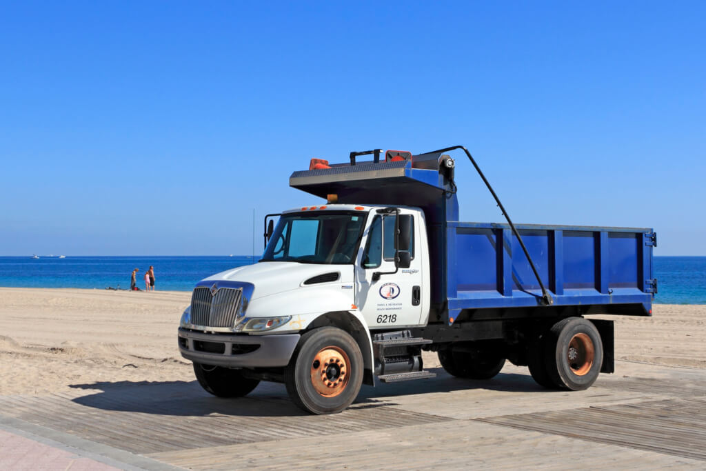 Blue and white dump truck parked on wooden platform in Fort Lauderdale Florida