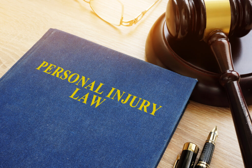 Personal injury law book on a desk next to a gavel